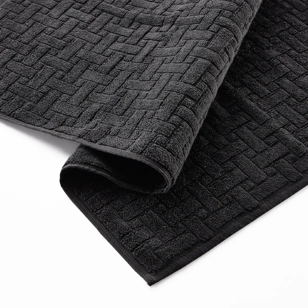 Charcoal product detail Glodina Embossed Bath Mat in Charcoal folded to show the raised geometric texture and finished edging
